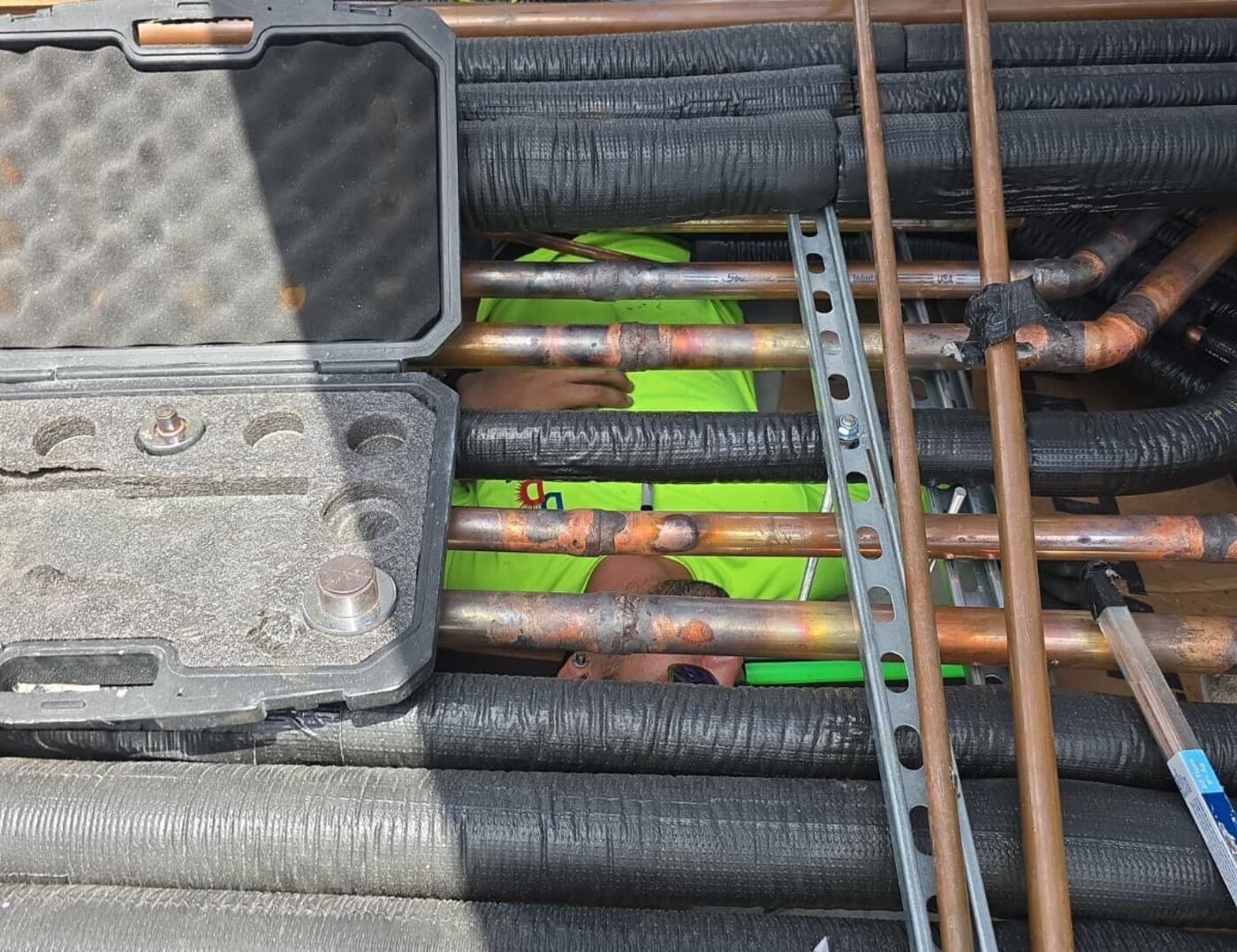 Insulated refrigerant lines and copper piping being fitted on a Miami Beach high-rise
